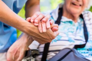 Person Consoling Senior Woman Holding Her Hand
