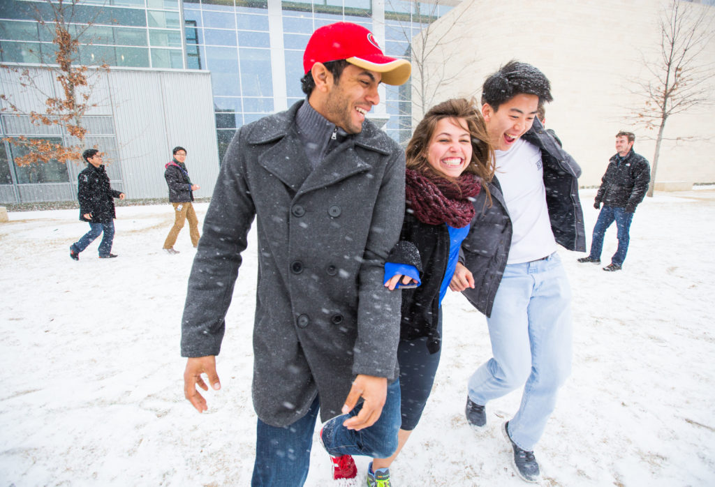 students in winter clothes on the snow covered MET lawn