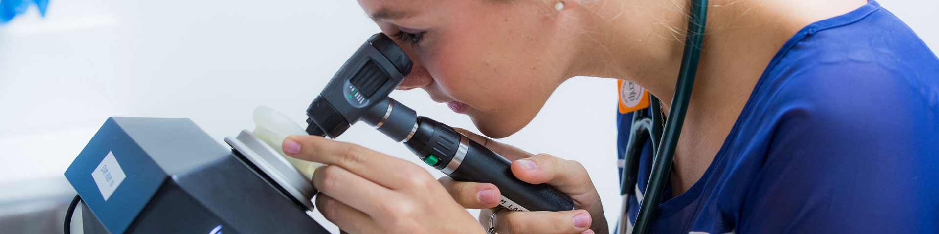 a student looking through a microscope