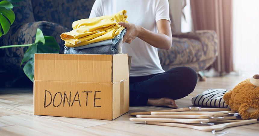 Woman Holding Clothes With Donate Box In Her Room, Donation Conc