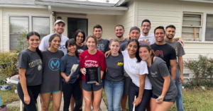 HSC student volunteers stand outside for Habitat For Humanity house