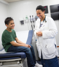 Dr. Christina Robinson preforms eye exam on young boy