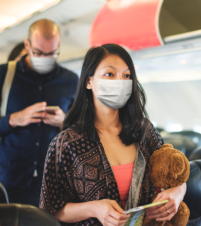 People wearing face masks boarding airplane