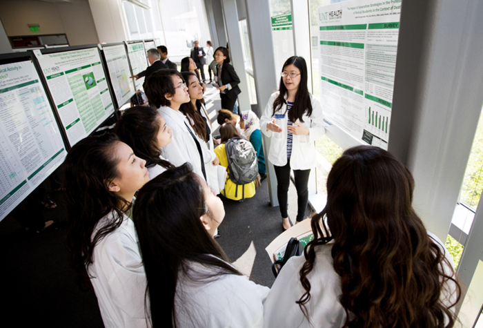 Students discussing research at poster presentation