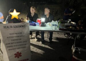 Student volunteer helps take health intake for a person in need.