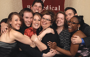 Group of students hugging staff member at awards banquet