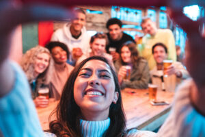 Happy Friends Taking A Group Selfie At Pub
