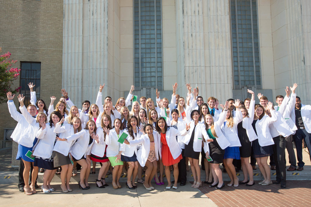 students receiving their white coats