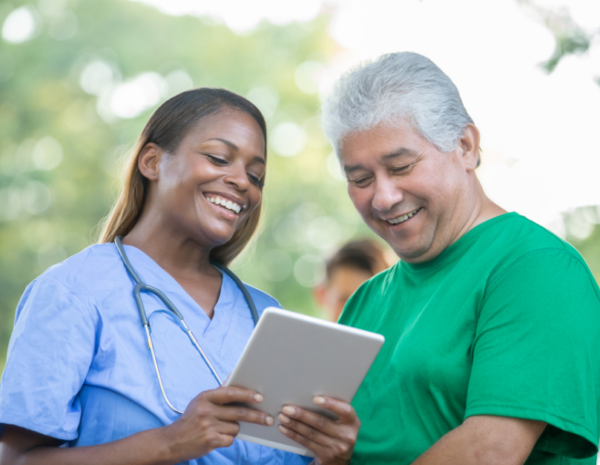 medical professional viewing document with male patient at an outdoor health fair