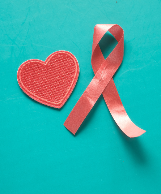 HIV awareness red ribbon and a heart on a turquoise background.