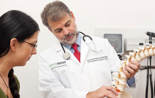 Dr. Lichiardone examining a model of a human spine