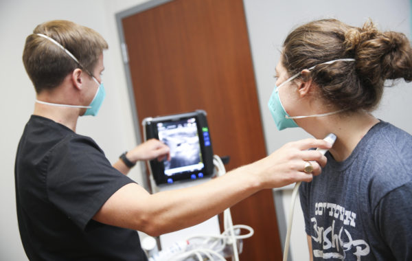 students using an ultrasound machine on each other