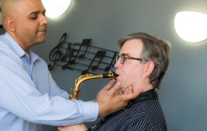 doctor evaluating saxophone player's jaw line