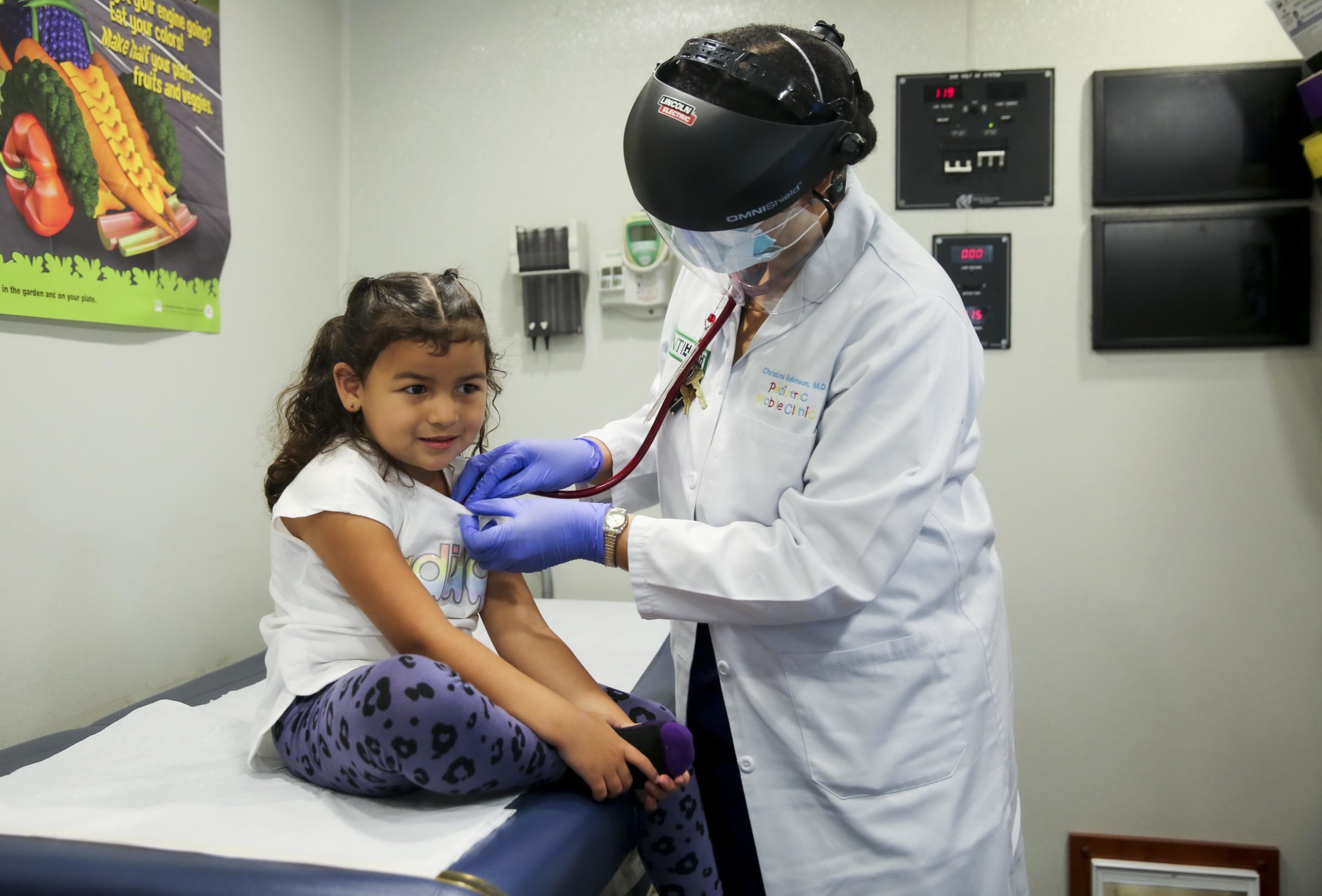 a doctor listening to a child's heartbeat with a stethoscope